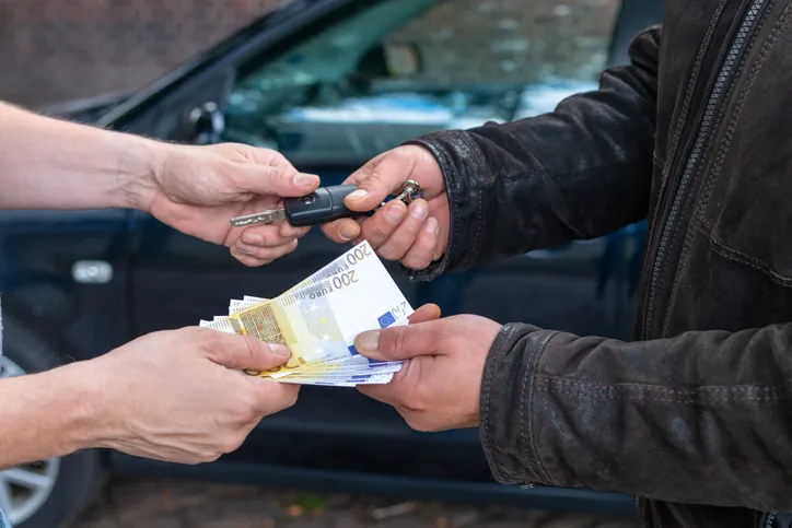 Seller receiving cash for their car at pickup