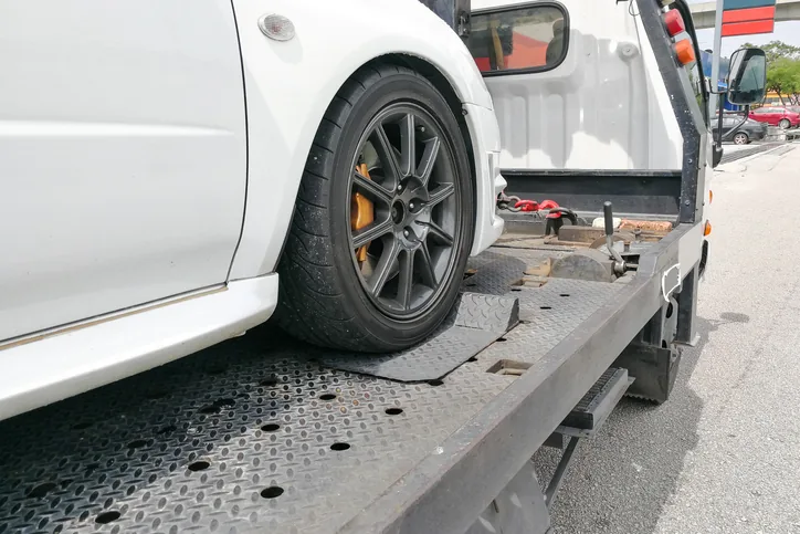 Car being loaded onto a flatbed tow truck